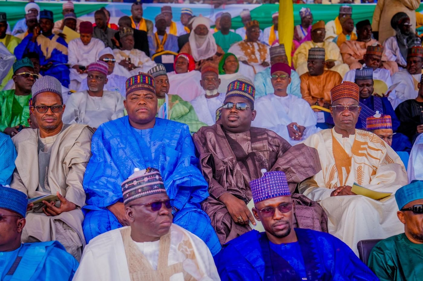 Delegates in traditional attire seated in the front rows at a political event