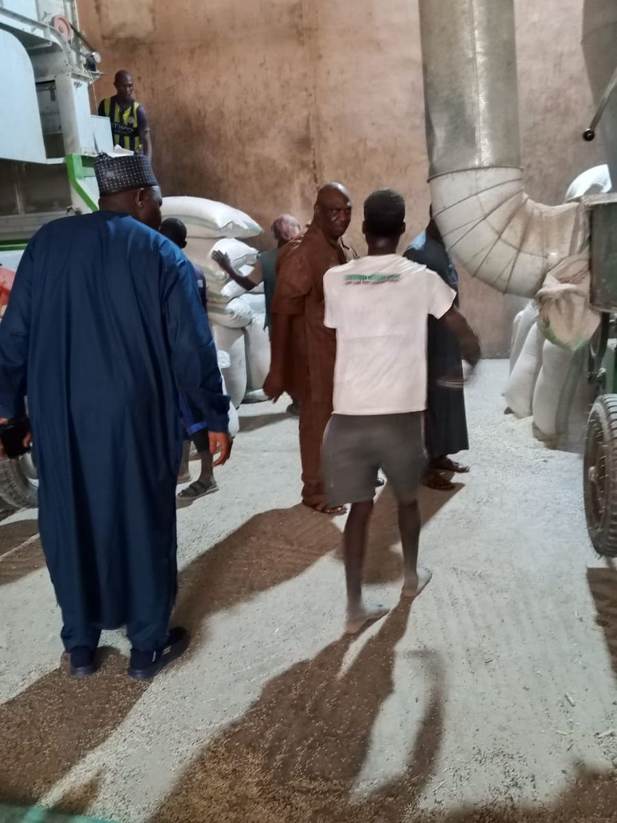 Workers handling bagged commodities inside a warehouse